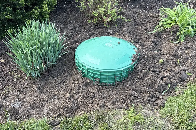 Finished green lid set into a flowerbed